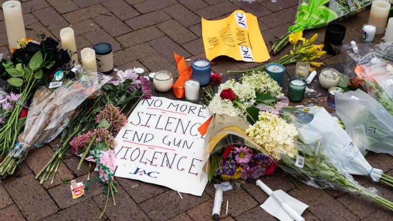 Signs and flowers are pictured at a makeshift memorial for victims of the July 4 mass shooting in downtown Highland Park, Illinois on July 6, 2022. (Max Herman  /AFP / Getty Images via CNN)