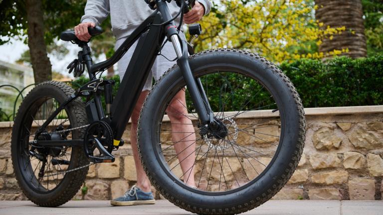 A man holds up an electronic bike in a file photo. (Taras Grebinets / iStock)