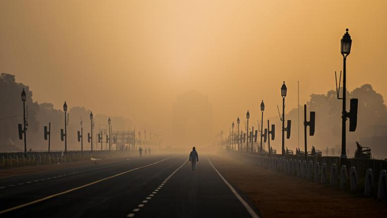 A man walks along Rajpath amid smoggy conditions in New Delhi on Jan. 28. Air pollution is shaving nearly six years off people's lives in the country, on average. (Jewel Samad / AFP / Getty Images)