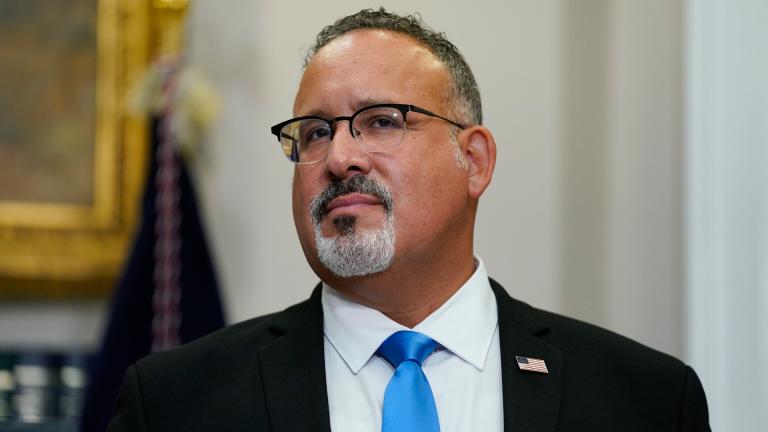 Education Secretary Miguel Cardona listens as President Joe Biden speaks about student loan debt forgiveness at the White House on Aug. 24, 2022. (Evan Vucci / AP)