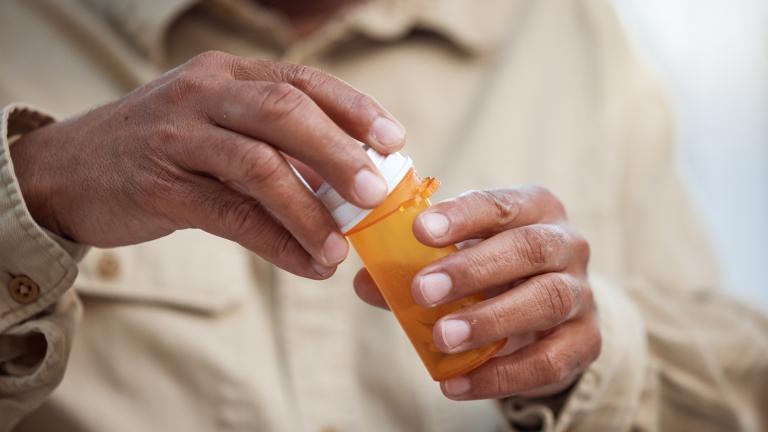 File photo of a person holding a pill container. (Jacob Wackerhausen / iStock)