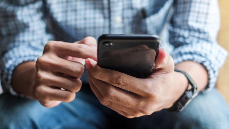 A man holds a phone in his hand. (iStock)