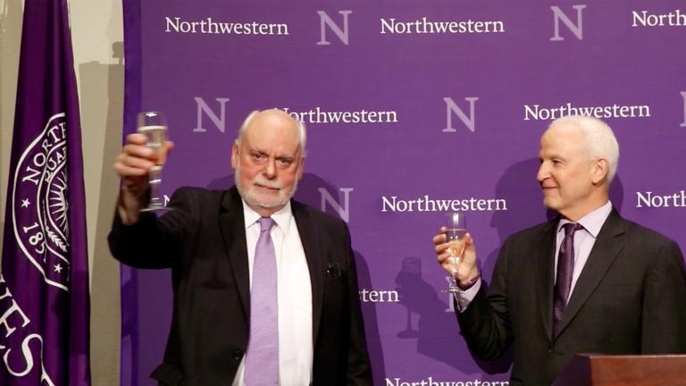 Northwestern University chemistry professor Sir Fraser Stoddart, left, raises his glass at a ceremony celebrating his Nobel Prize win. (Evan Garcia / Chicago Tonight)