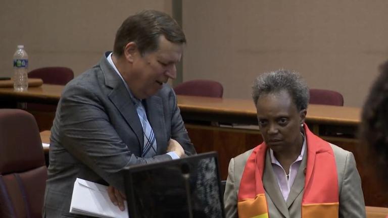 Former Ald. Joe Moore, who now works as a lobbyist, speaks with Mayor Lori Lightfoot on the floor of the City Council chambers on June 22, 2022. (WTTW News)