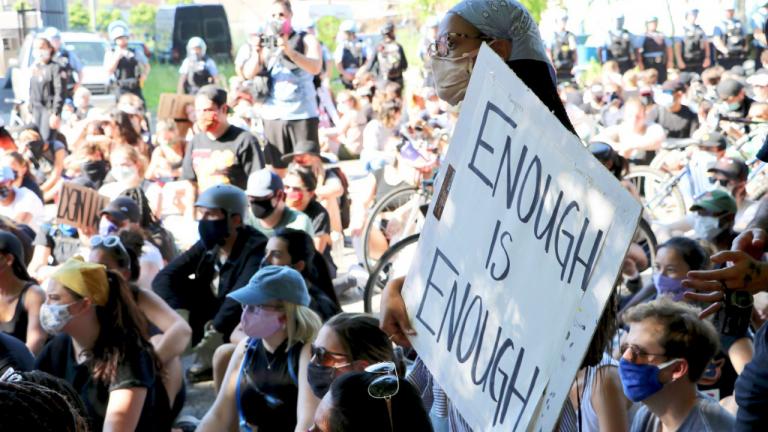 A woman holds a sign reading “Enough Is Enough” during a protest on June 2, 2020 in Old Town. (Evan Garcia / WTTW News)