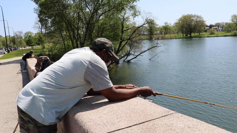 Fishermen Wayne Hankins (right) and Stephen Williams (left) fish off a bridge in Jackson Park on Chicago’s South Side on May 23. (Evan Garcia / WTTW News)