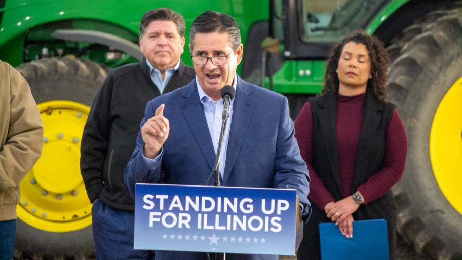 Jerry Costello II, director of the Illinois Department of Agriculture, speaks at a Christian County farm alongside Gov. JB Pritzker (left) and Cameron Joost, assistant director of the Illinois Department of Commerce and Economic Opportunity. The group discussed the impact of tariffs on Illinois farmers in an October visit. (Jerry Nowicki / Capitol News Illinois)