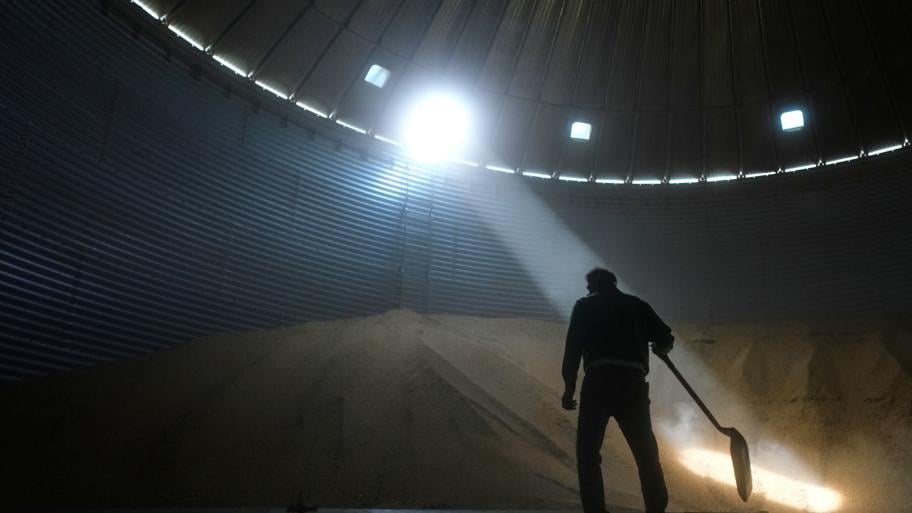 Doug Bartek shovels soybeans in a bin on his farm near Wahoo, Neb., on Monday, April 6, 2026. (AP Photo/Charlie Riedel)