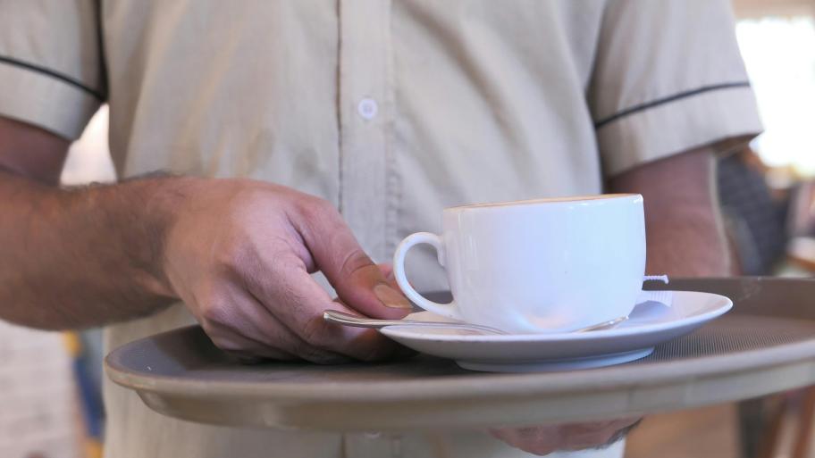 A waiter with a coffee cup is pictured in a file photo. (Credit: Towfiqu barbhuiya / Pexels)
