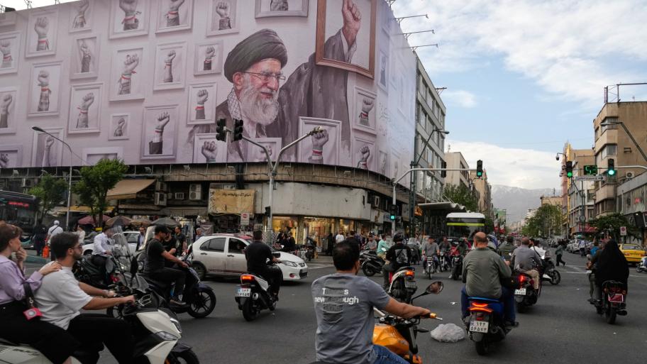 Motorbikes drive past a billboard with graphic showing the late Iranian Supreme Leader Ayatollah Ali Khamenei, who was killed in the U.S. and Israel strikes on Feb. 28, with his framed fist amongst his supporters framed fists in downtown Tehran, Iran, Wednesday, May 6, 2026. (AP Photo / Vahid Salemi)