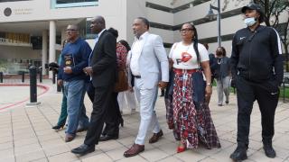 FILE - Attorney Ben Crump, second from left, walks with Ron Lacks, left, Alfred Lacks Carter, third from left, both grandsons of Henrietta Lacks, and other descendants of Lacks, outside the federal courthouse in Baltimore, Oct. 4, 2021. (Steve Ruark / AP Photo, file)
