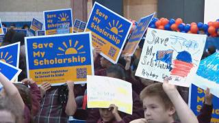 Kids with signs encouraging lawmakers to extend the Invest in Kids Act. (WTTW News)