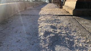 A heavily salted sidewalk crossing along the North Branch of the Chicago River, in early 2022. (Patty Wetli / WTTW News)