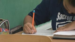 A student writing on paper. (WTTW News)