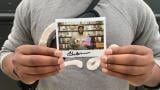 Harold Moore, 40, of Austin poses with a polaroid of him inside the Criterion Mobile Closet on Oct. 17, 2025. He picked out Mira Nair’s “Mississippi Masala” (1991), a Robert Downey Sr. film collection and a Melvin Van Peebles film collection. (Eunice Alpasan / WTTW News)