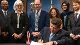 Gov. JB Pritzker signs the Artificial Intelligence Safety Measures Act into law in Chicago on July 6, 2026, surrounded by lawmakers and advocates. (Maggie Dougherty / Capitol News Illinois)