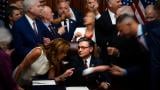 Republican members of Congress reach to shake hands with Speaker of the House Mike Johnson, R-La., center bottom, after Johnson signed President Donald Trump’s signature bill of tax breaks and spending cuts, Thursday, July 3, 2025, at the Capitol in Washington. (AP Photo / Julia Demaree Nikhinson)