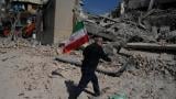 A man carries an Iranian flag to place on the rubble of a police facility struck during the U.S.–Israeli military campaign in Tehran, Iran, Wednesday, March 4, 2026. (AP Photo / Vahid Salemi)