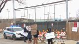 Protesters stand at the entrance of a Brighton Park lot that will eventually be used as a base camp for migrants arriving in Chicago on Nov. 27, 2023. (WTTW News) 