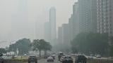 The iconic John Hancock Center is reduced to a faint silhouette behind a thick shroud of Canadian wildfire smoke as vehicles head southbound on DuSable Lake Shore Drive near the Gold Coast neighborhood on Thursday, July 16, 2026. (Victor Hilitski / WTTW News)