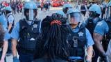 A protester faces a line of police officers in Chicago on Saturday, May 30, 2020. (Hugo Balta / WTTW News)