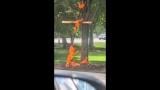 This grab from a video taken by motorist Keinika Carlton shows a wooden cross engulfed in bright orange flames as it leans against a tree in Grant Park, Chicago, Illinois, on Tuesday, July 9, 2026. (Keinika Carlton via AP)