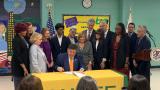 Gov. JB Pritzker signs a law on July 31, 2025, at Chute Middle School in Evanston to implement universal mental health screenings in Illinois schools. (Eunice Alpasan / WTTW News)