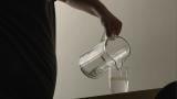 Someone pours a glass of water into a pitcher. (Medill)