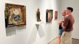 Attendees of Expo Chicago admire works by Luis A. Sahagún on April 12, 2024. (Angel Idowu / WTTW News)