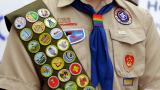 FILE - Merit badges and a rainbow-colored neckerchief slider are affixed on a Boy Scout uniform outside the headquarters of Amazon in Seattle. (Ted S. Warren / AP Photo, File)