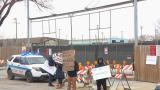 Protesters stand at the entrance of a Brighton Park lot that will eventually be used as a base camp for migrants arriving in Chicago on Nov. 27, 2023. (WTTW News) Protesters stand at the entrance of a Brighton Park lot that will eventually be used as a base camp for migrants arriving in Chicago on Nov. 27, 2023. (WTTW News)