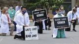 In this June 5, 2020 photo provided by the Mountain Area Health Education Center, physicians, residents and staff from the facility in Asheville, N.C., take a knee to show support for renewed calls for racial justice after the police killing of George Floyd. (Brenda Benik / MAHEC via AP) In this June 5, 2020 photo provided by the Mountain Area Health Education Center, physicians, residents and staff from the facility in Asheville, N.C., take a knee to show support for renewed calls for racial justice after the police killing of George Floyd. (Brenda Benik / MAHEC via AP)