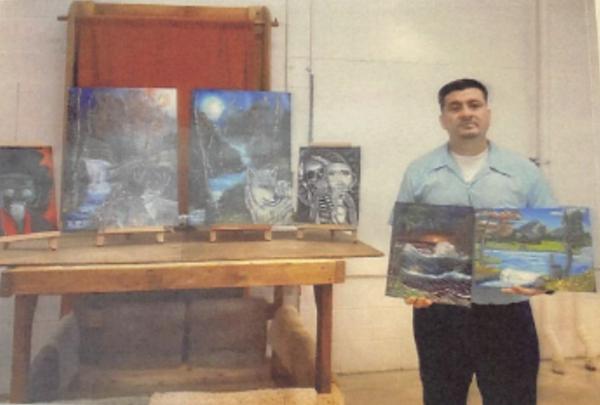 Manuel Cervantes poses with some of his artwork. (Courtesy of Stephanie Matthews)