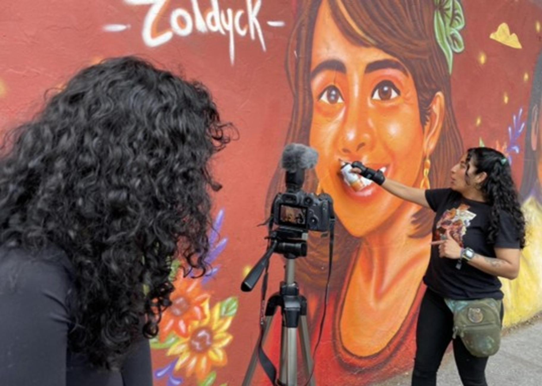 Melissa Zoldyck, new to the Juntas mural scene, describes her painting process. (Daniela Cantu / Medill School of Journalism)