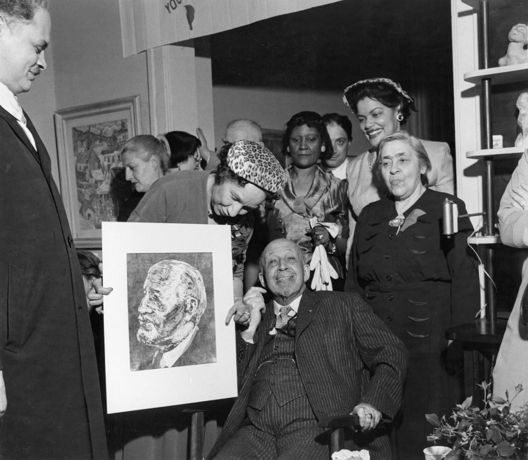 W.E.B Du Bois, Shirley Graham Du Bois, and artist Bernard Goss with his birthday portrait of Du Bois. (Special Collections and University Archives, University of Massachusetts Amherst Libraries)