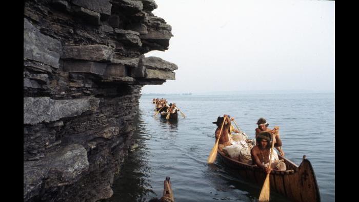 Paddling past a limestone spire on Lake Ontario, August 26, 1976. The canoe at the front contains Rich Gross, Bob Kulick, Reid Lewis, and John DiFulvio. (Photographers of the La Salle: Expedition II).