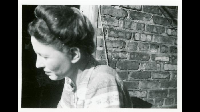 Simone de Beauvoir, by a brick wall. (Photographer unknown but may be Algren. OSU archive, used with permission of Algren estate)