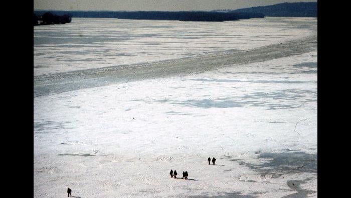 Men walk down the frozen Illinois River near Grafton, Illinois, on February 7, 1977. (Photographers of the La Salle: Expedition II)