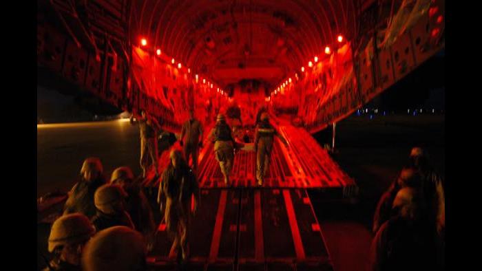United States military personnel load injured soldiers onto a cargo plane en route to Germany from the Balad airforce base. (Lynsey Addario)