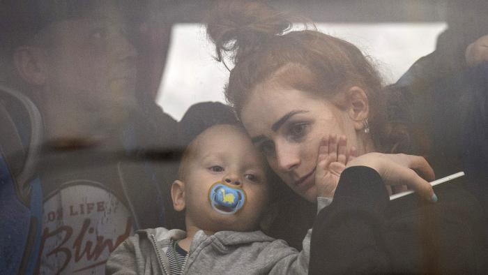 A woman holds her baby inside a bus as they leave Kyiv, Ukraine, Thursday, Feb. 24, 2022. (AP Photo / Emilio Morenatti)