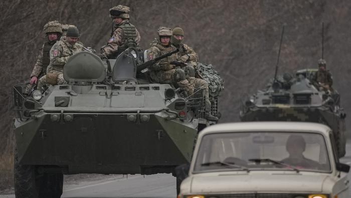 Ukrainian servicemen sit atop armored personnel carriers driving on a road in the Donetsk region, eastern Ukraine, Thursday, Feb. 24, 2022. (AP Photo / Vadim Ghirda)