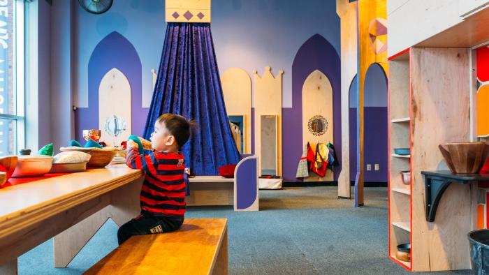 A young child plays at the communal table at the "Once Upon a Castle" exhibit. (Courtesy of Chicago Children's Museum)