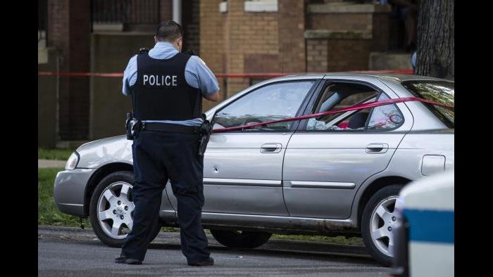 A Chicago police officer investigates the scene of a shooting in Chicago on Sunday, July 5, 2020. (Ashlee Rezin Garcia / Chicago Sun-Times via AP)