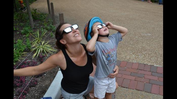 Maria Opdycke and her son try out their solar glasses at Lincoln Park Zoo. (Alex Ruppenthal / Chicago Tonight)