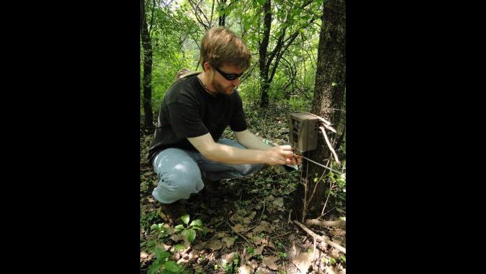 Dr. Seth Magle places a wildlife camera trap.