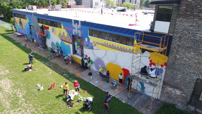 Painting the garden's El Abrazo murals was a communal project. (Courtesy of El Paseo Community Garden)