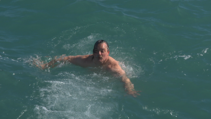 Dan O’Conor swims back to a lakefront ladder at Fullerton Beach after diving headfirst into Lake Michigan on Feb. 26, 2021. (WTTW News)