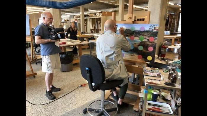 WTTW videographer Tom Siegel films the conservation treatment of a painting.