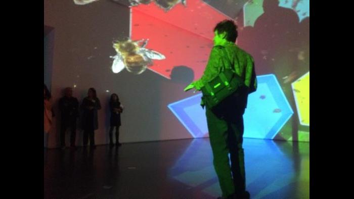 A visitor at the MCA considers the multicolored hexagons and bees that comprise “knots + surfaces.” (2001)