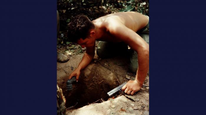 Tunnel Rat, 1967. Flashlight and .45 pistol in hand, a squad leader from the U.S. Army 25th Infantry Division searches for the enemy in an underground tunnel in Củ Chi, northwest of Saigon. Photo by Specialist 5 Robert C. Lafoon, U.S. Army.